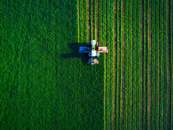 Tractor In Green Field, Ag BioTech, Inc. a Biostimulants and Fertilizer Supplier